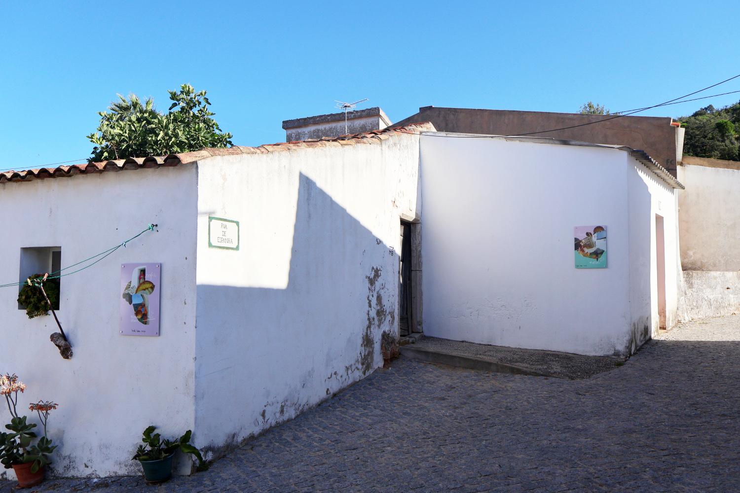 Street exhibition with visual compositions installed across village houses, Aldeia da Penina